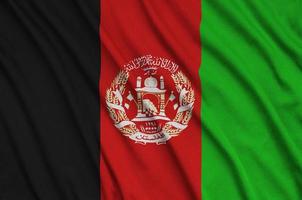 Afghanistan flag is depicted on a sports cloth fabric with many folds. Sport team banner photo