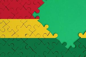 Bolivia flag  is depicted on a completed jigsaw puzzle with free green copy space on the right side photo