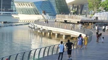 loopbrug in de buurt modern glas structuur louis vuitton gebouw in jachthaven baai zand toevlucht in Singapore video