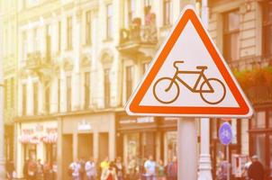 A road sign with a picture of a bicycle against a crowded street. Cycling allowed photo