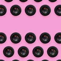 A few camera lenses with a closed aperture lie on texture background of fashion pastel pink color paper in minimal concept. Abstract trendy pattern photo