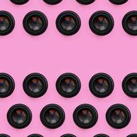 A few camera lenses with a closed aperture lie on texture background of fashion pastel pink color paper in minimal concept. Abstract trendy pattern photo