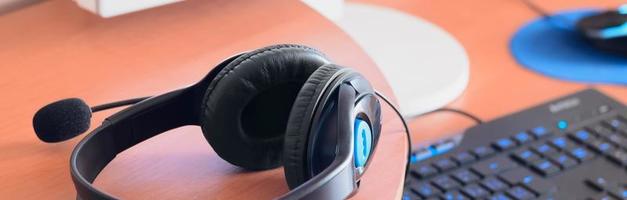 Big black headphones lie on the wooden desktop of the sound designer photo