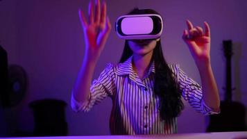 niña que aplica auriculares de realidad virtual durante el trabajo en casa por la noche, concepto de tecnología moderna