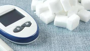 Digital blood sugar monitor on table with sugar cubes video