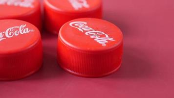 Close up of red branded coco cola bottle tops video