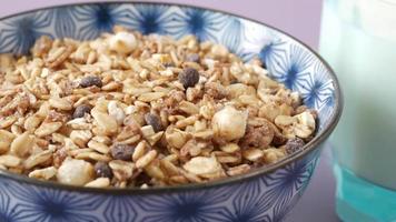 Granola with chocolate chips in a bowl close up rotating video