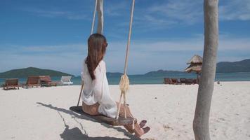 joven asiática relajándose en la arena de la playa en el hermoso fondo de la isla marina, concepto de vacaciones video