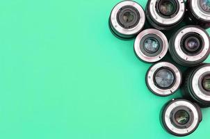 Several photographic lenses lie on a bright turquoise background. Copy space photo