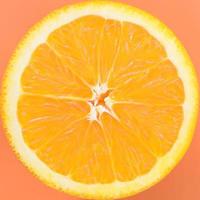 Top view of a one orange fruit slice on bright background in orange color. A saturated citrus texture image photo