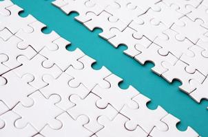 The blue path is laid on the platform of a white folded jigsaw puzzle. Texture image with copy space for text photo