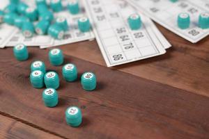 Many barrels with numbers and cards for lotto or russian bingo table game on wooden surface. Russian lotto has similar rules to classical worldwide bingo photo