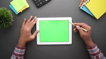 visão de mesa aérea com notebooks calculadora e planta usa uma caneta e um tablet com tela verde video