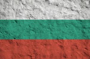 Bulgaria flag depicted in bright paint colors on old relief plastering wall. Textured banner on rough background photo