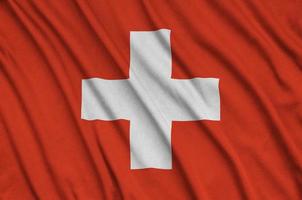 Switzerland flag  is depicted on a sports cloth fabric with many folds. Sport team banner photo