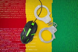Guinea flag  and handcuffed computer mouse. Combating computer crime, hackers and piracy photo