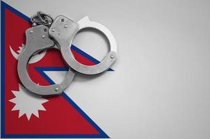 Nepal flag  and police handcuffs. The concept of crime and offenses in the country photo
