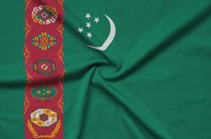 Turkmenistan flag  is depicted on a sports cloth fabric with many folds. Sport team banner photo