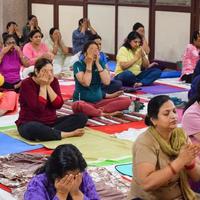 New Delhi, India, June 19 2022 -Group Yoga exercise session for people of different age groups in Balaji Temple, Vivek Vihar, International Yoga Day, Big group of adults attending yoga class in temple photo