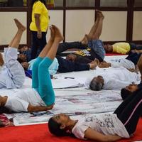 New Delhi, India, June 19 2022 -Group Yoga exercise session for people of different age groups in Balaji Temple, Vivek Vihar, International Yoga Day, Big group of adults attending yoga class in temple photo