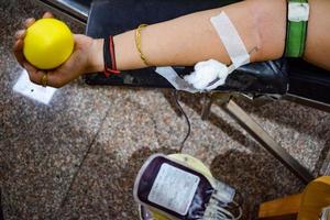 donante de sangre en el campamento de donación de sangre sostenido con una pelota hinchable en la mano en el templo balaji, vivek vihar, delhi, india, imagen para el día mundial del donante de sangre el 14 de junio de cada año, campamento de donación de sangre foto