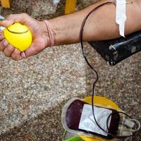 Blood donor at Blood donation camp held with a bouncy ball holding in hand at Balaji Temple, Vivek Vihar, Delhi, India, Image for World blood donor day on June 14 every year, Blood Donation Camp photo