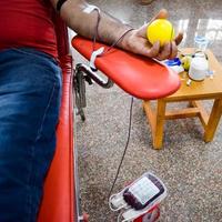 Blood donor at Blood donation camp held with a bouncy ball holding in hand at Balaji Temple, Vivek Vihar, Delhi, India, Image for World blood donor day on June 14 every year, Blood Donation Camp photo