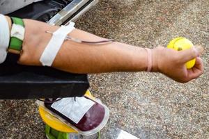 Blood donor at Blood donation camp held with a bouncy ball holding in hand at Balaji Temple, Vivek Vihar, Delhi, India, Image for World blood donor day on June 14 every year, Blood Donation Camp photo