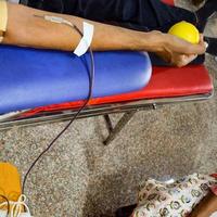 Blood donor at Blood donation camp held with a bouncy ball holding in hand at Balaji Temple, Vivek Vihar, Delhi, India, Image for World blood donor day on June 14 every year, Blood Donation Camp photo