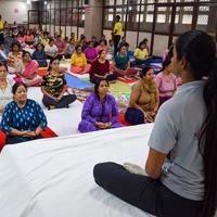 New Delhi, India, June 19 2022 -Group Yoga exercise session for people of different age groups in Balaji Temple, Vivek Vihar, International Yoga Day, Big group of adults attending yoga class in temple photo