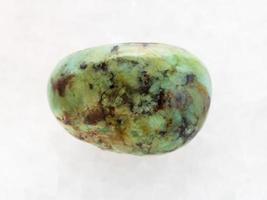 african turquoise gemstone on white marble photo