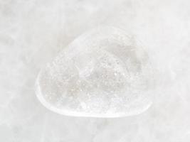 piedra de gema de cristal de roca caída sobre mármol blanco foto