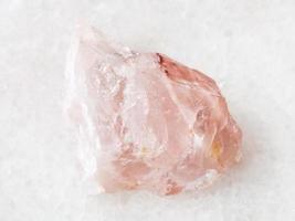 raw crystal of rose quartz gemstone on white photo