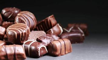 Assortment of chocolates piled together on black surface