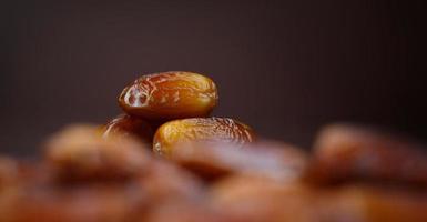 Dates lie on the background of other dates. Ripe dried dates. photo