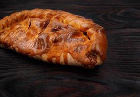 Homemade pie lies on a wooden surface. photo