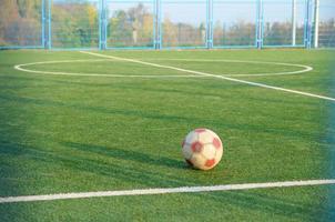 Classic soccer ball on football green grass field outdoor. Active sports and physical training photo