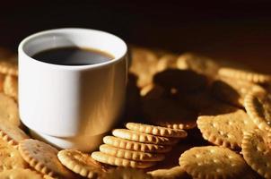 taza de café pequeña y galleta salada foto