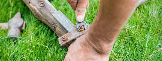 Elderly man twists the nut by wrench photo