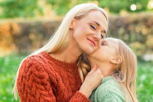 Daughter kisses her young mother photo