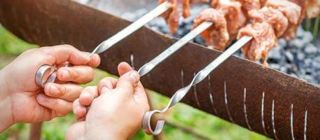 Hands of man prepares barbecue meat photo