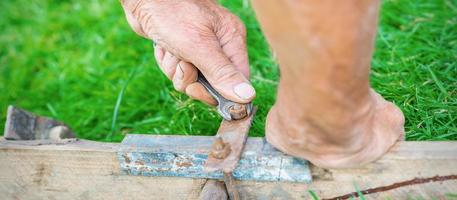 Elderly man twists the nut by wrench photo