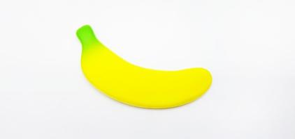 Fake banana isolated on white background. Small toy, shape and object. concept. Not real of fruit photo