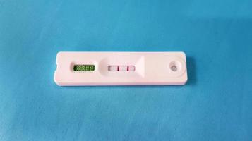 Positive test result by use antigen rapid test for COVID-19 isolated on blue background with copy space. Healthy check, Corona virus infection, Pandemic infectious and Medical. Initial symptom check. photo