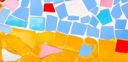 colorido del suelo de baldosas de mosaico para el fondo. papel pintado de diseño de arte, agrietado, forma y abstracto. Fragmentos de azulejo azul, rojo, rosa, naranja, blanco en la pared. foto