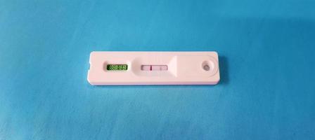 Positive test result by use antigen rapid test for COVID-19 isolated on blue background with copy space. Healthy check, Corona virus infection, Pandemic infectious and Medical. Initial symptom check. photo