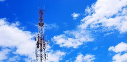 Red and white telecommunication, broadcast TV, digital television, radio, Transmission, microwave or mobile tower with blue sky and cloud background and copy space. Technology and telecom equipment photo