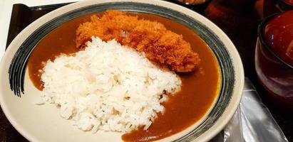 Close up spicy curry rice with deep fried beef or pork on dish at Japan restaurant. Asian food on plate in Japanese style photo