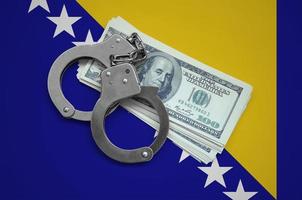 Bosnia and Herzegovina flag  with handcuffs and a bundle of dollars. Currency corruption in the country. Financial crimes photo