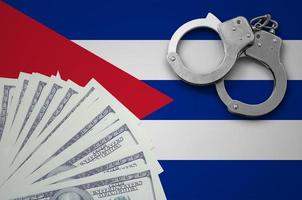 Cuba flag  with handcuffs and a bundle of dollars. The concept of illegal banking operations in US currency photo